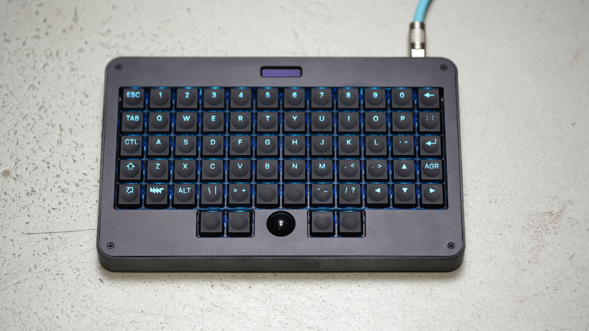 photo of MNT Pocket Reform Standalone Keyboard with cyan backlight